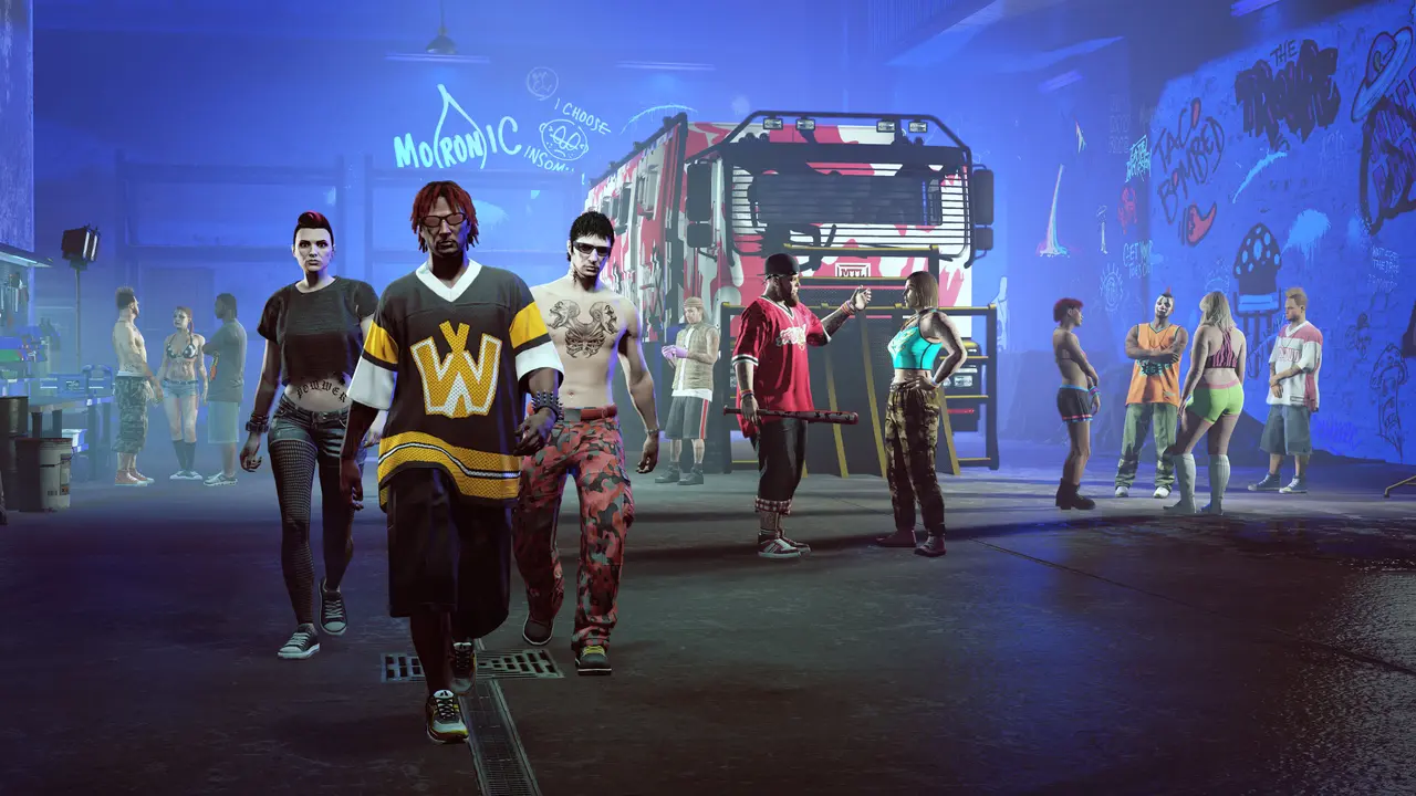 L'intérieur du Freakshop dans GTA Online, un hangar éclairé au néon bleu couvert de graffitis, avec l'équipage des Fooligans qui avance vers la caméra et le camion Brickade 6x6 à camouflage rouge et blanc garé au fond