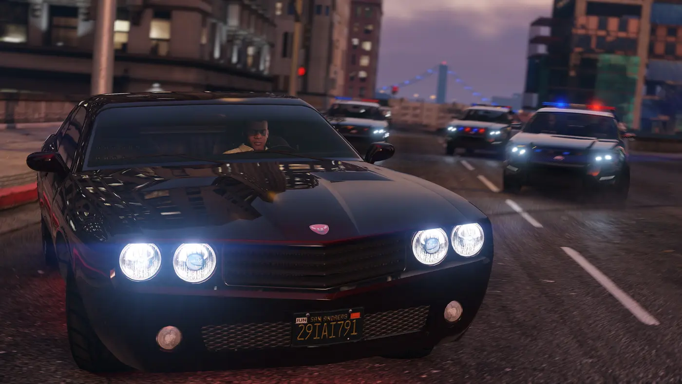 Franklin au volant d'une muscle car noire dans une rue du centre de Los Santos dans GTA 5, poursuivi par plusieurs voitures de police