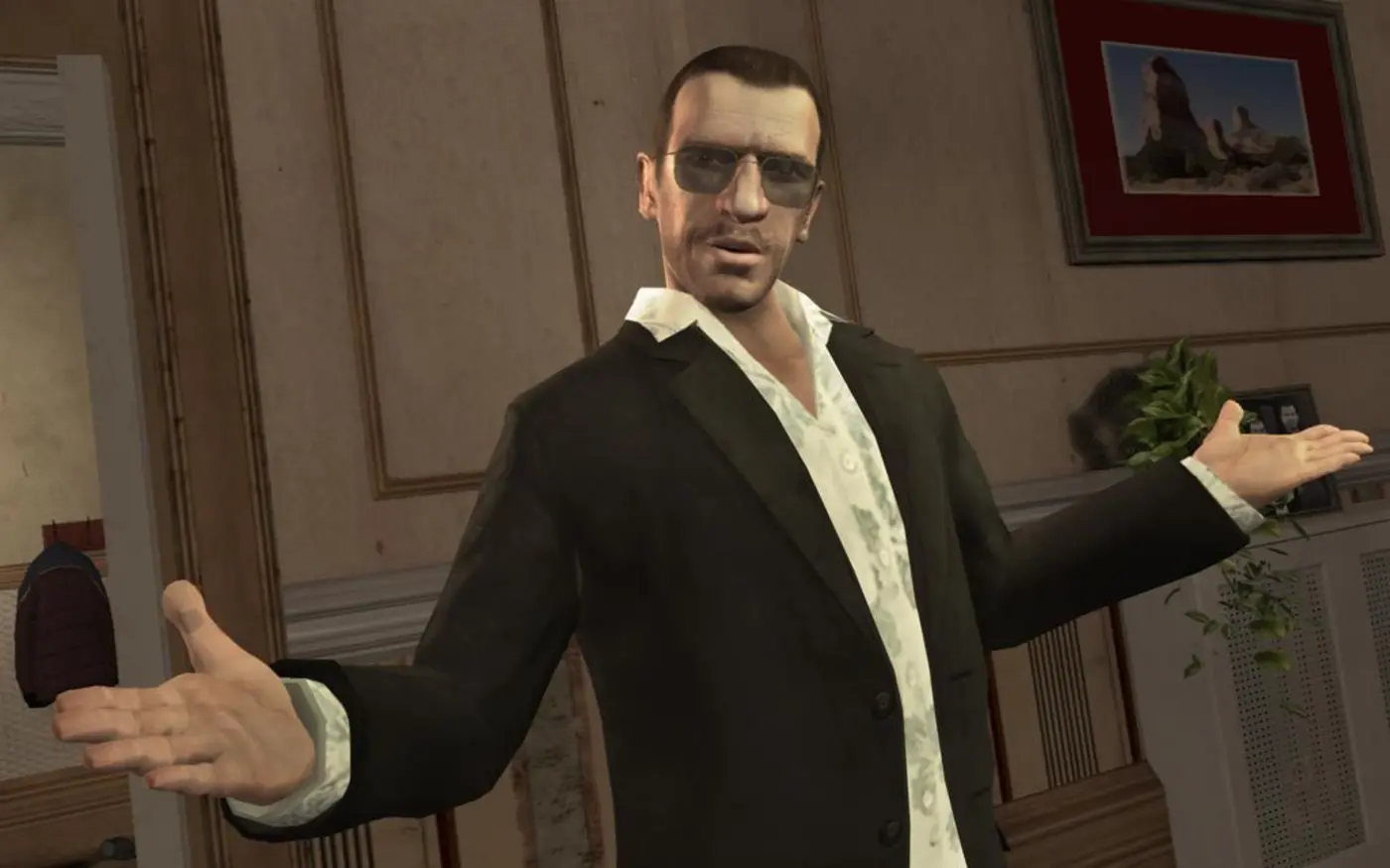 Niko Bellic, lunettes de soleil et blazer sombre sur chemise à motifs, écarte les bras dans un appartement de Liberty City dans GTA IV