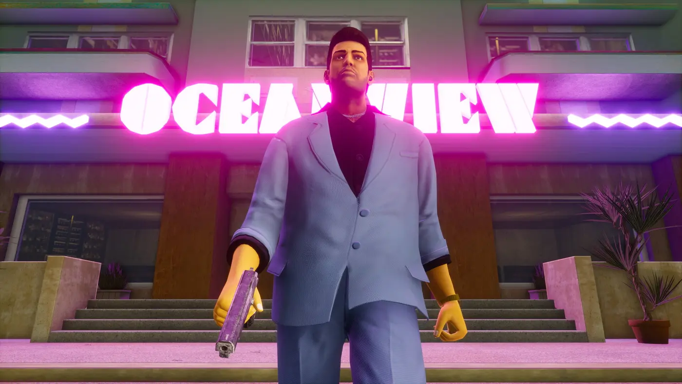 Tommy Vercetti en costume bleu clair, pistolet à la main, devant l'enseigne néon rose de l'hôtel Ocean View à Vice City