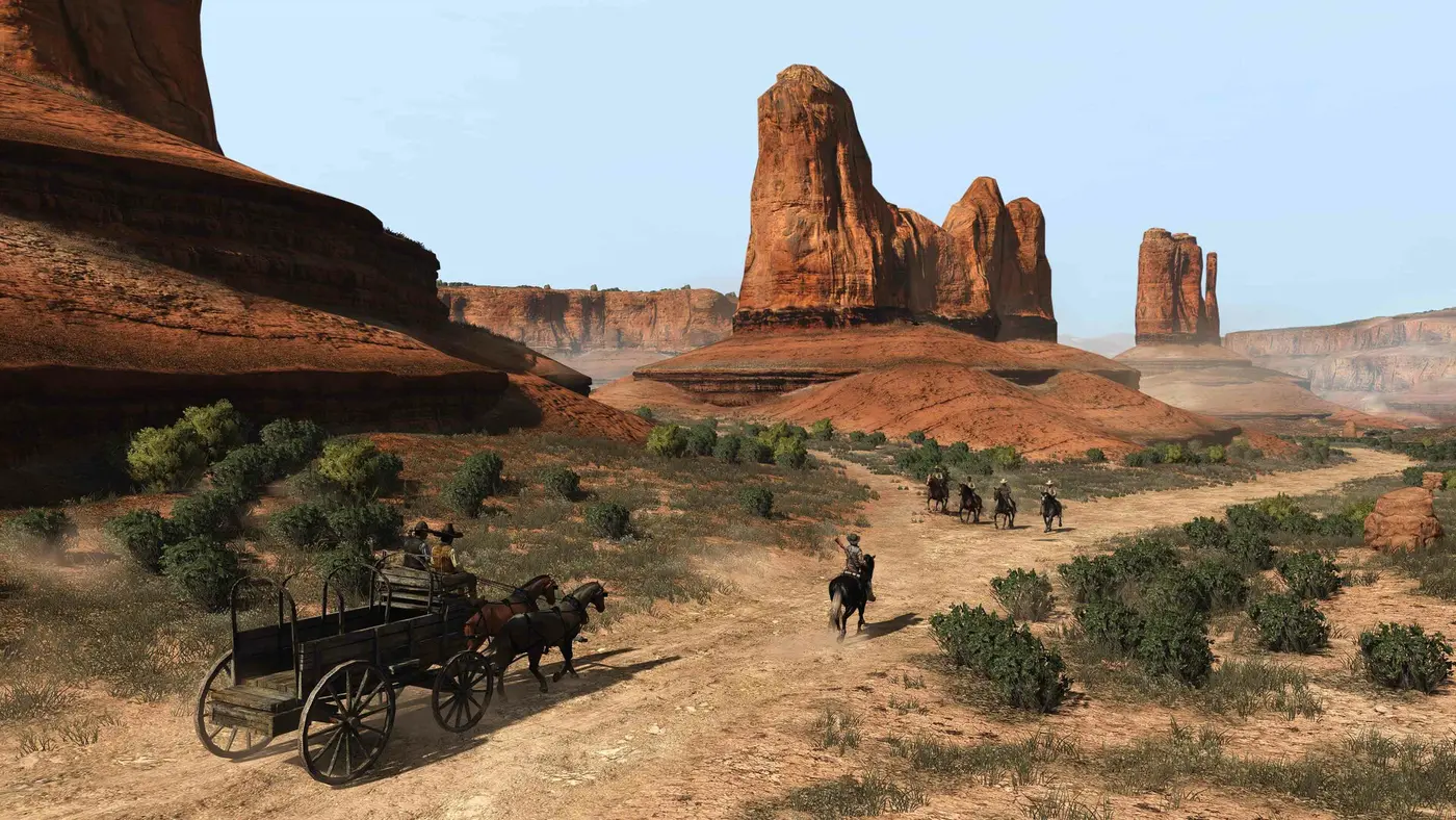 Diligence et cavaliers traversant une vaste vallée de roches rouges et de buttes désertiques sous un ciel clair dans Red Dead Redemption