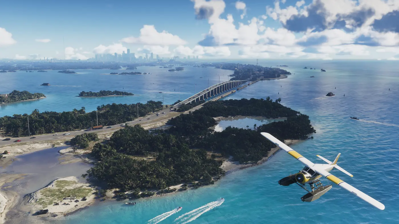 Vue aérienne des Leonida Keys dans GTA VI : un hydravion blanc et jaune survole un archipel turquoise, des hors-bords laissent des sillages et des voitures roulent sur un long pont à chaussée, skyline de Vice City au loin