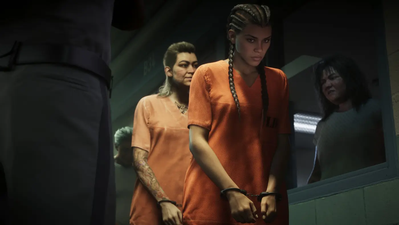 Lucia, protagoniste de GTA VI, en combinaison orange de détenue et menottée, escortée dans un couloir de prison avec d'autres détenues