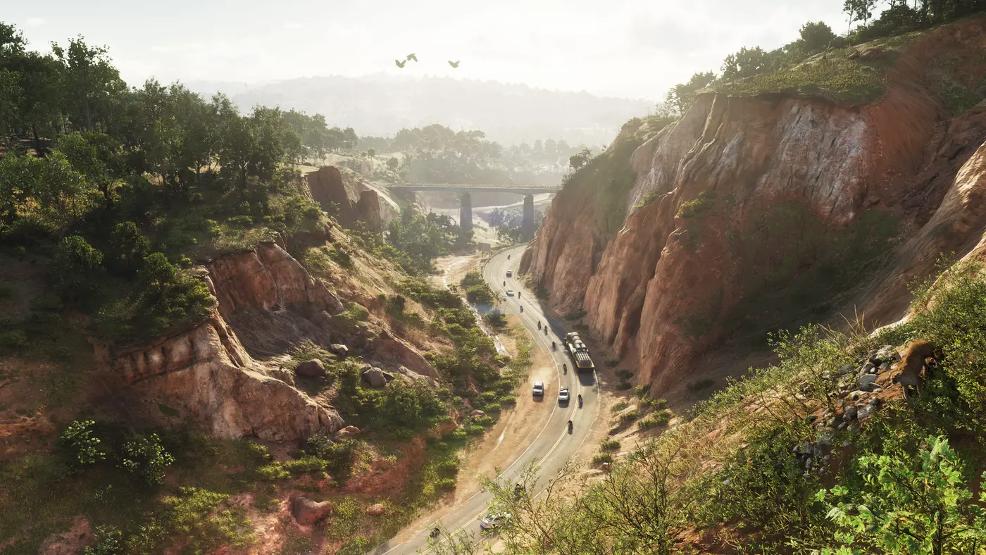 Un canyon aux falaises rouges de l'arrière-pays de Leonida dans GTA VI, une route sinueuse au fond de la gorge parcourue par des voitures, des motos et un poids lourd, un pont enjambant le ravin