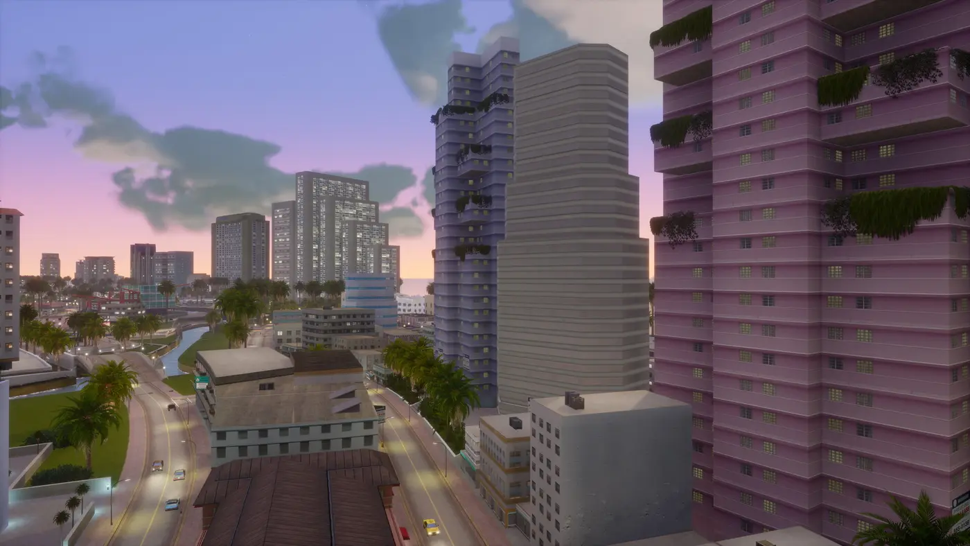 Vue en hauteur de la skyline de Vice City au crépuscule, gratte-ciels pastel, palmiers et avenue côtière sous un ciel rose et violet, dans GTA Vice City